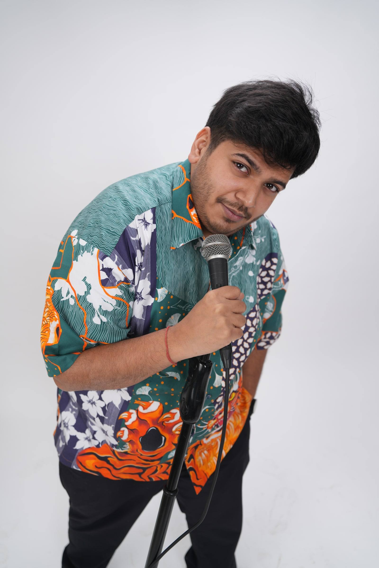 Kaustubh Agarwal leaning towards the camera over a microphone